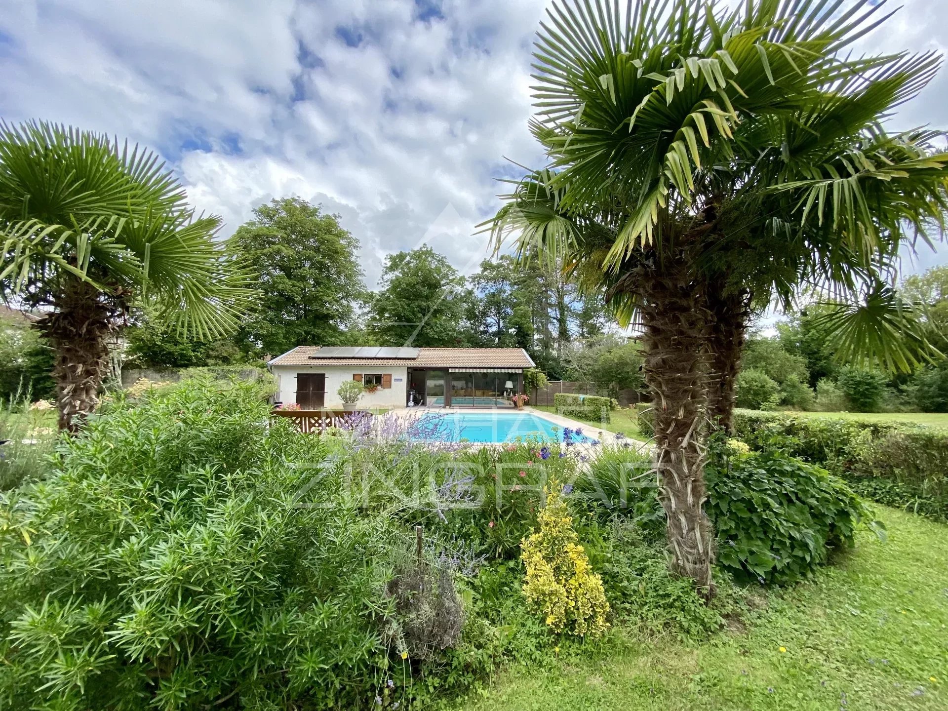 19th century house with swimming pool in wooded park along the river