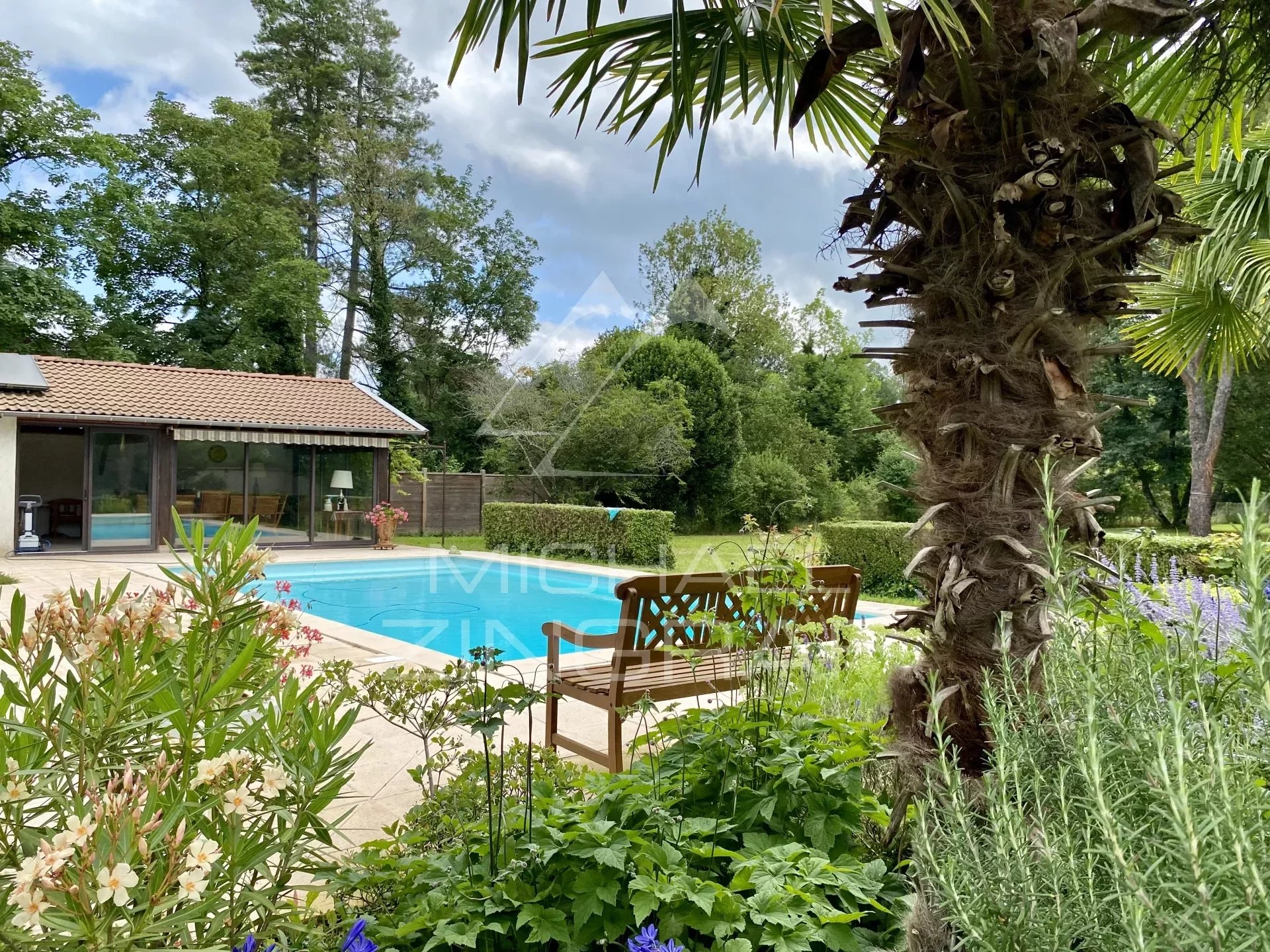 19th century house with swimming pool in wooded park along the river