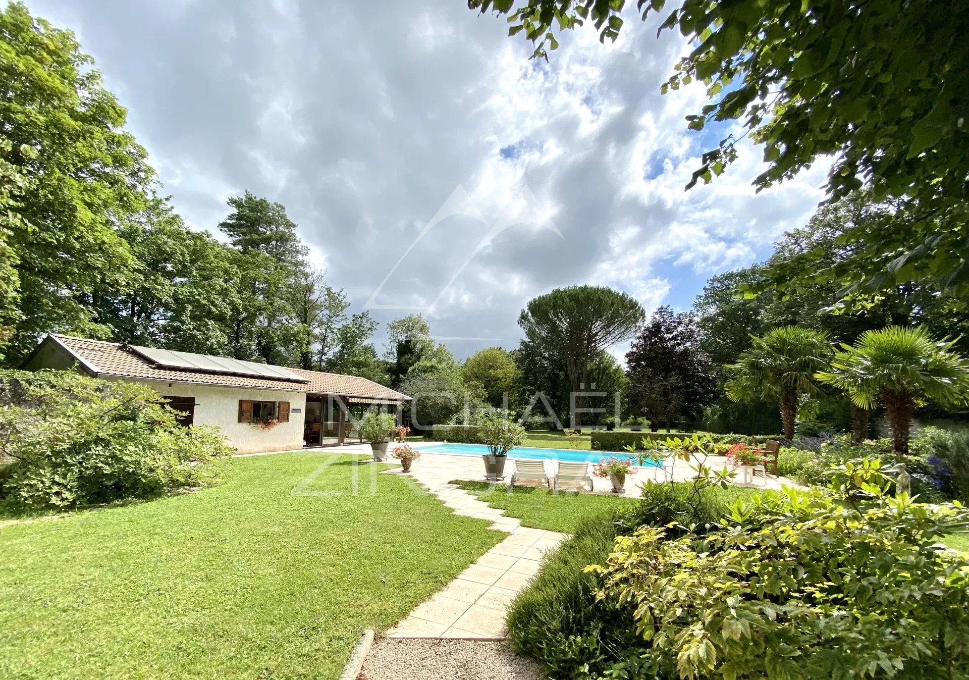 Haus aus dem 19. Jahrhundert mit Swimmingpool in einem bewaldeten Park am Fluss