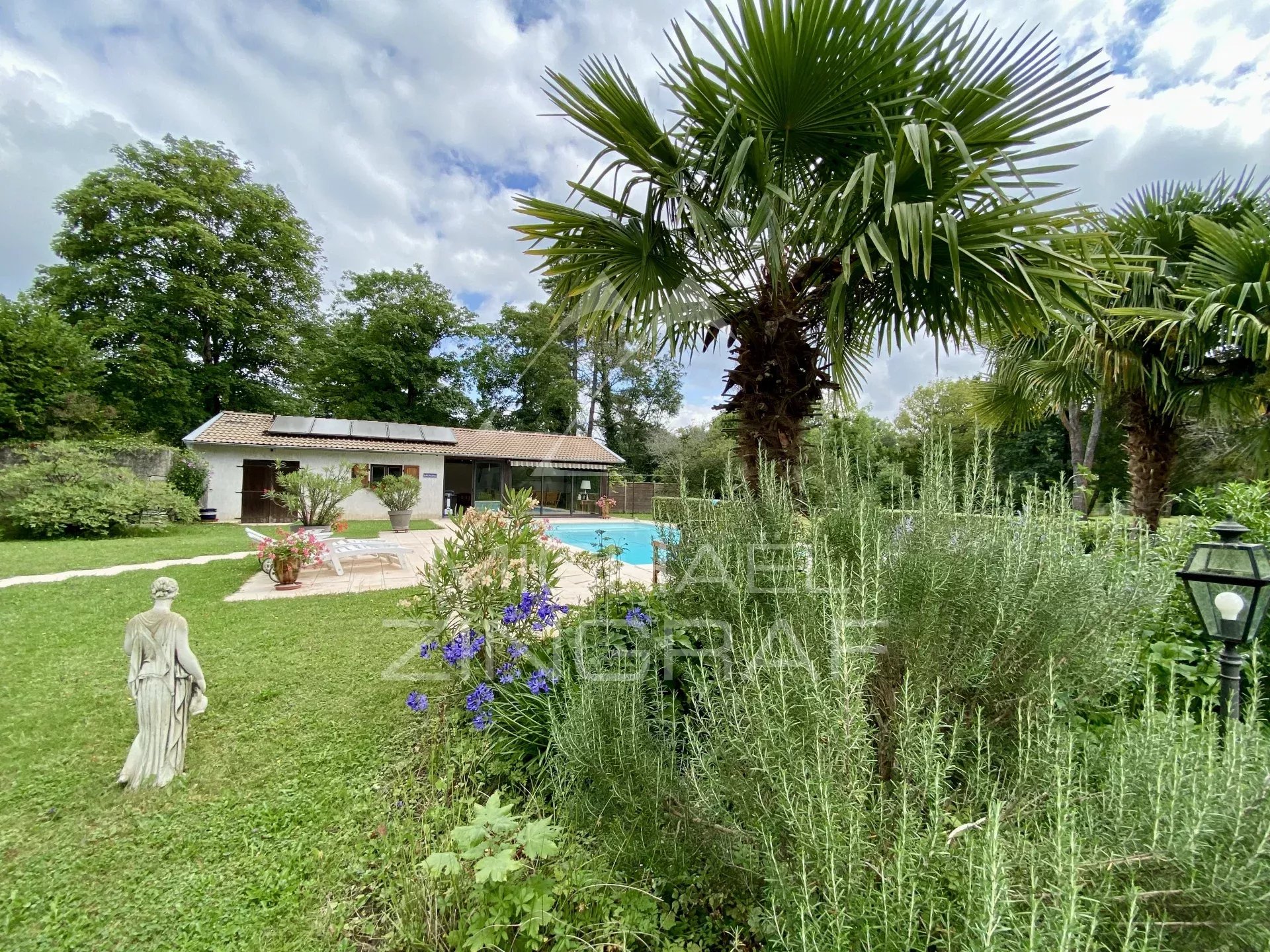 Haus aus dem 19. Jahrhundert mit Swimmingpool in einem bewaldeten Park am Fluss