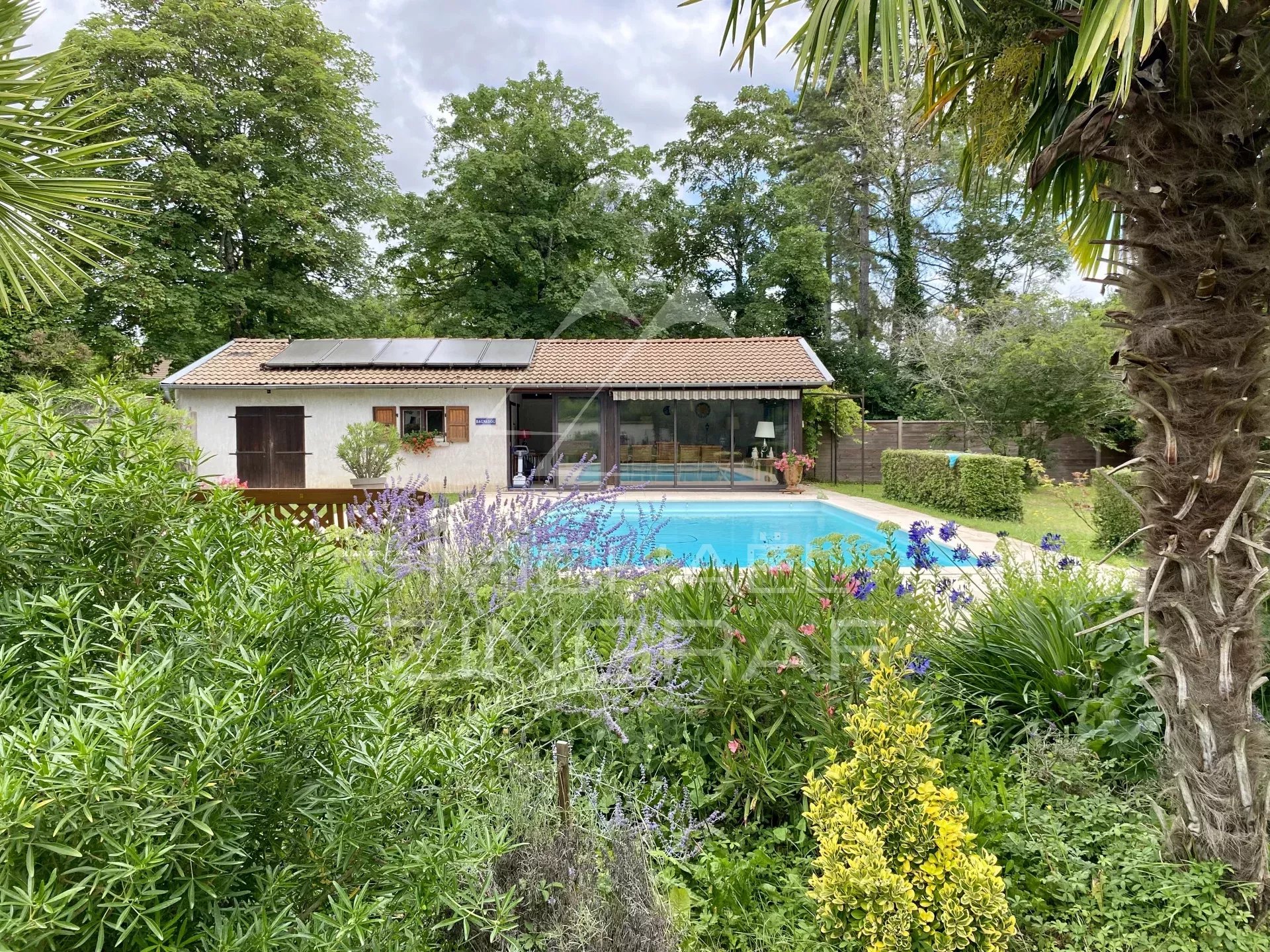 Haus aus dem 19. Jahrhundert mit Swimmingpool in einem bewaldeten Park am Fluss